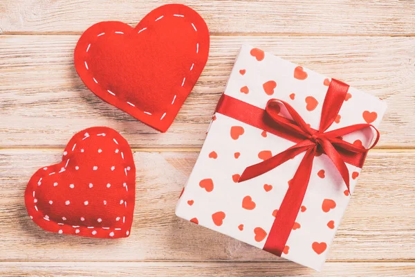 발렌타인 데이 또는 다른 휴일 수 제 종이에으로 현재 휴가 래퍼에 빨간 하트와 선물 상자. 디자인을 위한 오렌지 나무 테이블 복사 공간 평면도, 빈 공간에 선물 상자를 제시 — 스톡 사진