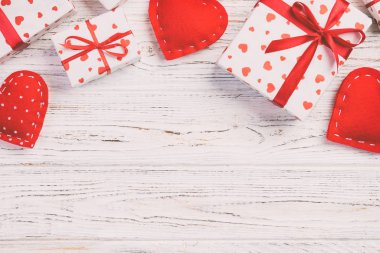 Sevgililer veya diğer tatil el yapımı mevcut kağıt ile tatil sarmalayıcı kırmızı kalpler ve hediye kutusunda. Tasarım için kopya alanı görünümüyle Beyaz ahşap masa üstü, boş alanı hediye kutusu
