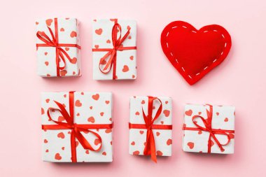 Hediye kutusu ile mercan arka plan üzerinde kırmızı kalpler. kopya alanı ile üstten görünüm