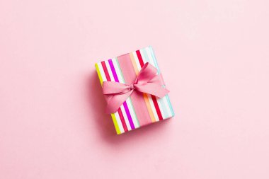 Pembe arka planda pembe kurdeleli el yapımı Noel hediyeleri. Şimdiki kutu, renkli tabloda hediye süslemesi, kopya alanı ile üst görünüm