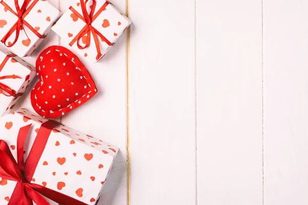 San Valentino o altre festività fatte a mano presenti in carta con cuori rossi e confezione regalo in involucro natalizio. Regalo scatola regalo su tavolo in legno bianco vista dall'alto con spazio copia, spazio vuoto per il design — Foto Stock