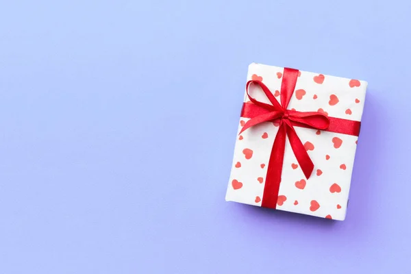 Kırmızı kurdele ve mor arka plan, metin kopyalama yeri olan üstten görünüm üzerinde kalp hediye kutusu — Stok fotoğraf