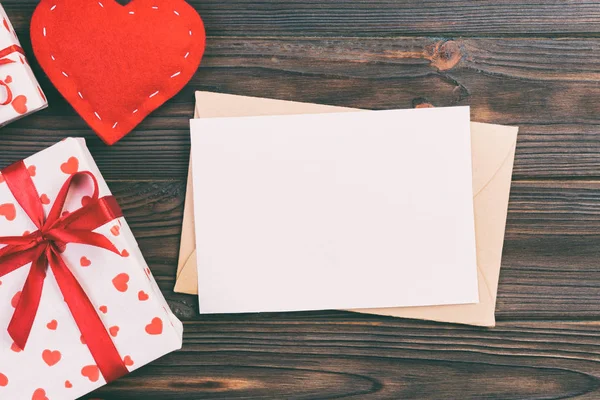 Envolvente de correo con corazón rojo y caja de regalo sobre fondo de madera oscura. Tarjeta de San Valentín, Amor o Boda Concepto de Saludo — Foto de Stock