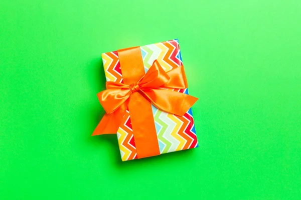 Draufsicht Weihnachtsgeschenkbox mit orangefarbener Schleife auf grünem Hintergrund mit Kopierraum — Stockfoto