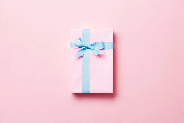 Caixa de presente com arco azul para o dia de Natal ou Ano Novo no fundo rosa, vista superior com espaço de cópia — Fotografia de Stock
