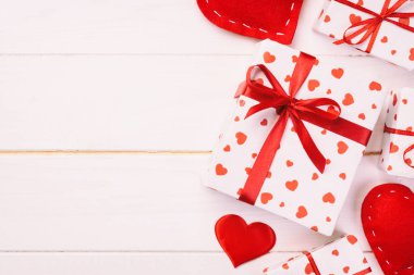 Sevgililer veya diğer tatil el yapımı mevcut kağıt ile tatil sarmalayıcı kırmızı kalpler ve hediye kutusunda. Tasarım için kopya alanı görünümüyle Beyaz ahşap masa üstü, boş alanı kutusu hediye sunmak