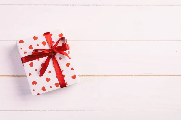 San Valentino o altre festività fatte a mano presenti in carta con cuori rossi e confezione regalo in involucro natalizio. Regalo scatola regalo su tavolo in legno bianco vista dall'alto con spazio copia, spazio vuoto per il design — Foto Stock