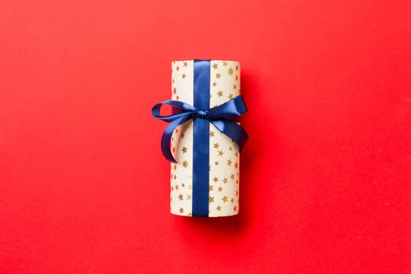 Noel için mavi fiyonklu hediye kutusu veya kırmızı zemin üzerinde yeni yıl günü, fotokopi alanı ile üst görünüm — Stok fotoğraf
