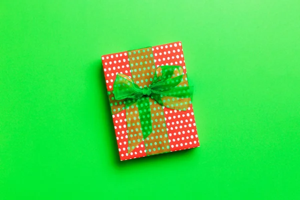 Top view Christmas present box with green bow on green background with copy space — Stock Photo, Image