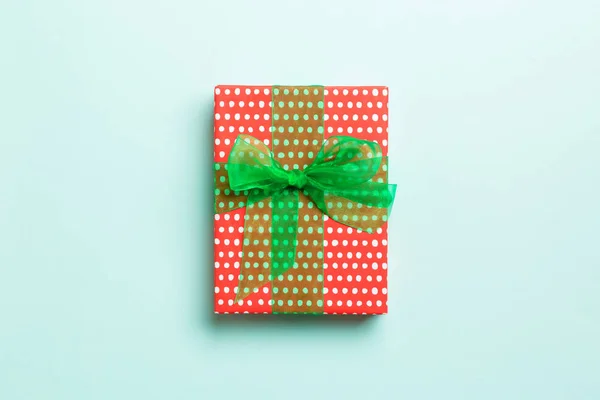 Загорнуті різдвяні або інші свята ручної роботи з паперу з зеленою стрічкою на синьому фоні. Подарункова коробка, прикраса подарунка на кольоровому столі, вид зверху з місцем для тексту — стокове фото