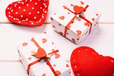 Sevgililer veya diğer tatil el yapımı mevcut kağıt ile tatil sarmalayıcı kırmızı kalpler ve hediye kutusunda. Tasarım için kopya alanı görünümüyle Beyaz ahşap masa üstü, boş alanı kutusu hediye sunmak