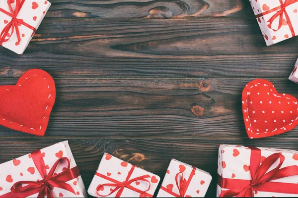 발렌타인 데이 또는 다른 휴일 수 제 종이에으로 현재 휴가 래퍼에 빨간 하트와 선물 상자. 디자인에 대 한 어두운 나무 테이블 상단 보기 복사 공간, 빈 공간에 선물 상자를 제시 — 스톡 사진