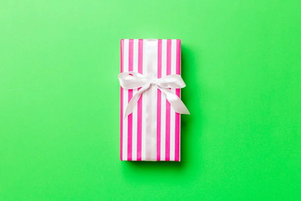 Cadeau doos met witte strik voor Kerstmis of Nieuwjaar dag op groene achtergrond, bovenaanzicht met kopieerruimte — Stockfoto