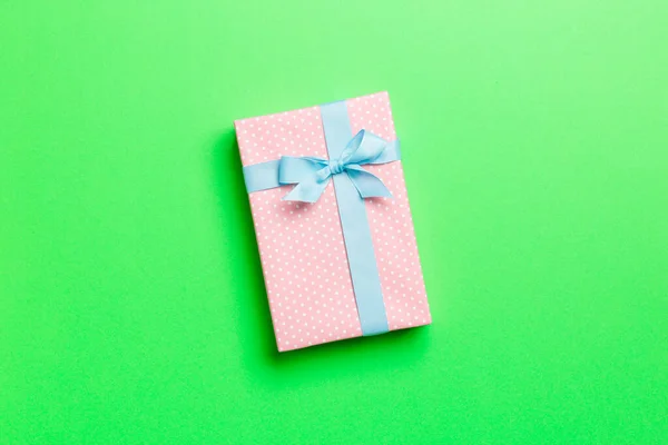 包装圣诞节或其他节日手工纸制礼物，蓝带绿色背景。礼品盒，彩色桌上的礼品装饰，顶部有复印空间 — 图库照片