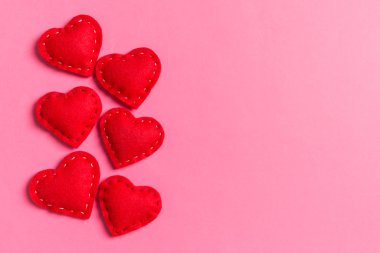 Renkli arka planda tekstil kalplerinin üst görüntüsü. Kopya alanı ile Sevgililer Günü konsepti