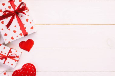 Sevgililer veya diğer tatil el yapımı mevcut kağıt ile tatil sarmalayıcı kırmızı kalpler ve hediye kutusunda. Tasarım için kopya alanı görünümüyle Beyaz ahşap masa üstü, boş alanı kutusu hediye sunmak