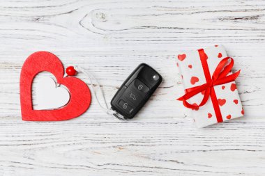 Tahta arka planda Sevgililer Günü hediyesinin üst görüntüsü. Arabanın anahtarını, hediye kutusunu ve kalbini kapat. Tatil için sürpriz konsept