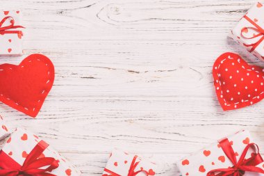 Sevgililer veya diğer tatil el yapımı mevcut kağıt ile tatil sarmalayıcı kırmızı kalpler ve hediye kutusunda. Tasarım için kopya alanı görünümüyle Beyaz ahşap masa üstü, boş alanı hediye kutusu