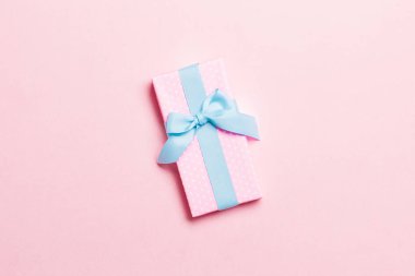 Üst görünüm Noel hediyesi kutusu üzerinde mavi fiyonk ve fotokopi alanı ile pembe arkaplan