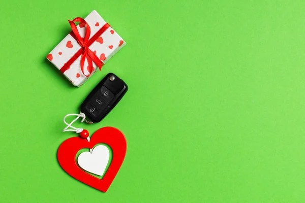 Ovanifrån av presentförpackning, bil nyckel och trä hjärta på färgglada bakgrund. Lyxpresent till alla hjärtans dag — Stockfoto