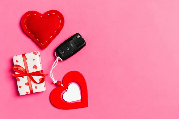 Ovanifrån av presentförpackning, bil nyckel, trä och textil hjärta på färgglada bakgrund. Lyxpresent till alla hjärtans dag — Stockfoto