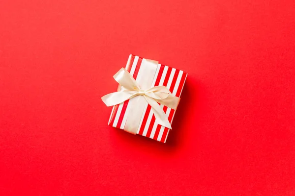 Caja de regalo con lazo amarillo para Navidad o Año Nuevo sobre fondo rojo, vista superior con espacio para copiar — Foto de Stock