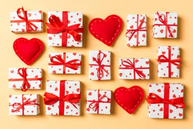 Beyaz hediye kutularının ve renkli arka planda kırmızı tekstil kalplerinin üst görüntüsü. Sevgililer Günü konsepti