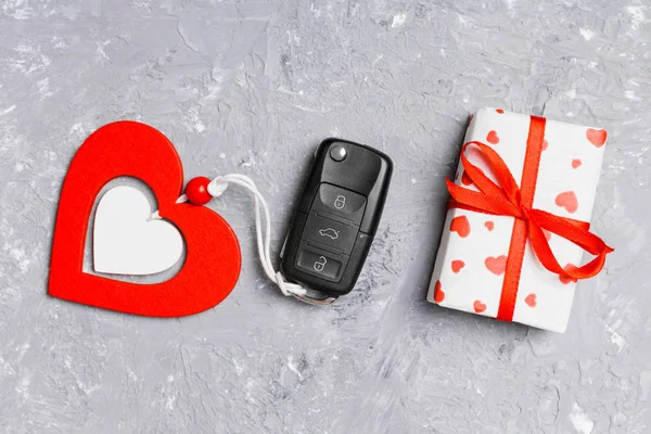 Top widok klucza samochodowego, pudełko prezentów i serca jako prezent na Walentynki na tle cementu. Pojęcie romantyzmu — Zdjęcie stockowe