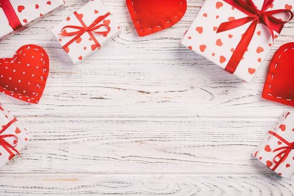 San Valentín u otro regalo hecho a mano en papel con corazones rojos y caja de regalos en envoltorio de vacaciones. Presente caja de regalo en vista superior de mesa de madera blanca con espacio para copiar, espacio vacío para el diseño — Foto de Stock