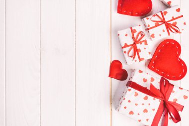 Sevgililer veya diğer tatil el yapımı mevcut kağıt ile tatil sarmalayıcı kırmızı kalpler ve hediye kutusunda. Tasarım için kopya alanı görünümüyle Beyaz ahşap masa üstü, boş alanı kutusu hediye sunmak