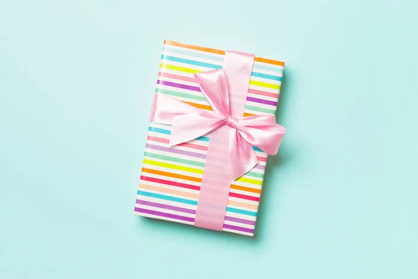 Gift box with pink bow for Christmas or New Year day on blue background, top view with copy space — Stock Photo, Image