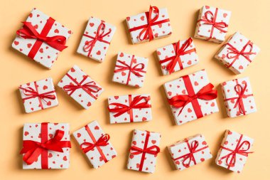 Renkli arka planda kırmızı kalpler olan tatil beyaz hediye kutularının kompozisyonu. Sevgililer Günü konsepti