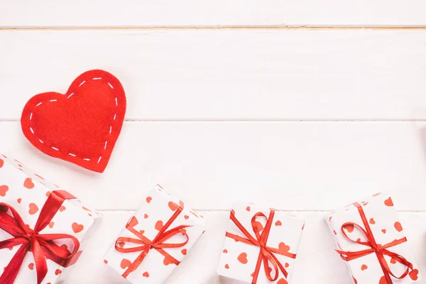 발렌타인 데이 또는 다른 휴일 수 제 종이에으로 현재 휴가 래퍼에 빨간 하트와 선물 상자. 선물 상자 흰색 나무 테이블 상단 보기 복사 공간, 빈 공간에 디자인에 대 한 — 스톡 사진