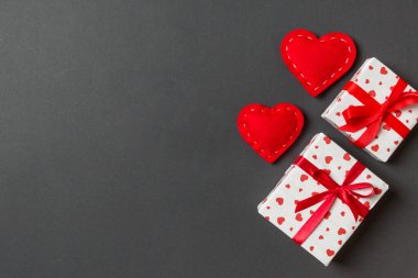 Hediye kutuları ve kırmızı tekstil kalplerden yapılmış üst görünüm renkli sevgililer günü arkaplanı. Kopya alanlı Sevgililer Günü konsepti