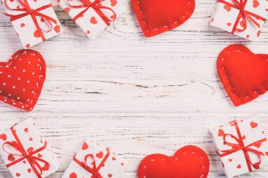 Sevgililer veya diğer tatil el yapımı mevcut kağıt ile tatil sarmalayıcı kırmızı kalpler ve hediye kutusunda. Tasarım için kopya alanı görünümüyle Beyaz ahşap masa üstü, boş alanı hediye kutusu