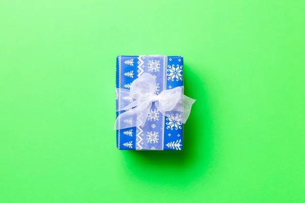 Enveloppé Noël ou autre cadeau de vacances fait à la main en papier avec ruban blanc sur fond vert. Coffret cadeau, décoration de cadeau sur table colorée, vue de dessus avec espace de copie. — Photo