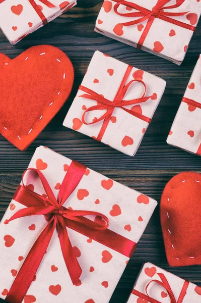 발렌타인 데이 또는 다른 휴일 수 제 종이에으로 현재 휴가 래퍼에 빨간 하트와 선물 상자. 디자인에 대 한 어두운 나무 테이블 상단 보기 복사 공간, 빈 공간에 선물 상자를 제시 — 스톡 사진
