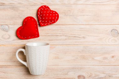 Tahta arka plandaki bir bardaktan fışkıran kalplerin üst görünümü. Aşk ve aşk kavramı. Sevgililer Günü