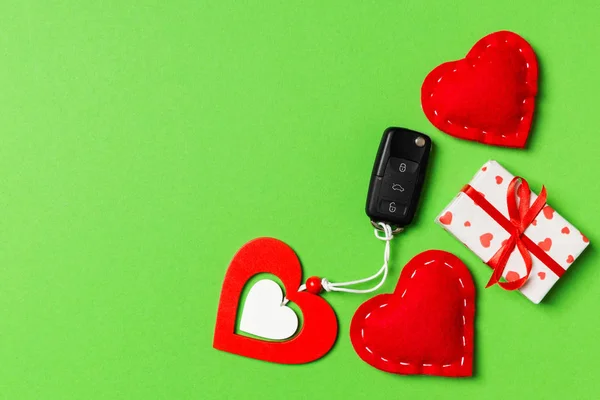 Ovanifrån av bil nyckel, presentförpackning och leksak hjärtan på färgglada bakgrund. Saint alla hjärtans dag koncept med kopia utrymme — Stockfoto