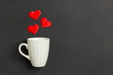 Kırmızı kalplerin renkli arka planda bir bardaktan düşüşünün bayram kompozisyonu. Kopya alanı ile Sevgililer Günü konseptinin en üst görüntüsü