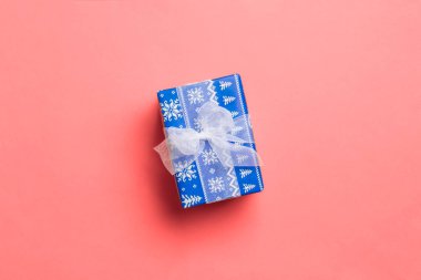 Yaşayan mercan arka planında beyaz kurdeleli kağıtlara sarılmış Noel veya diğer tatil hediyeleri. Şimdiki kutu, renkli tabloda hediye süslemesi, kopya alanı ile üst görünüm