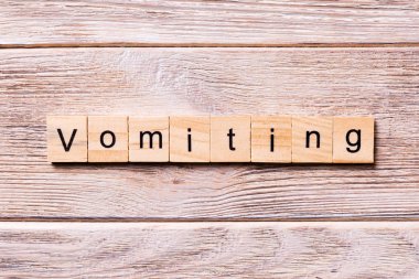 Tahta blokta yazan kusma kelimesi. Koronavirüs konseptiniz için ahşap masanın üzerine kusma metni.