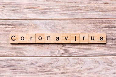 Tahta blokta Coronavirus kelimesi yazılı. Tahta masadaki Coronavirus metni, konsept üst görünümün için.