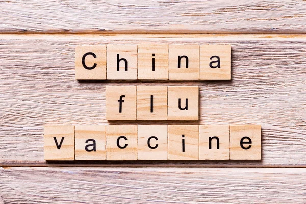 Cina vaccino antinfluenzale parola scritta su blocco di legno. Cina vaccino antinfluenzale testo sul tavolo di legno per il vostro desing, coronavirus concetto vista dall'alto — Foto Stock