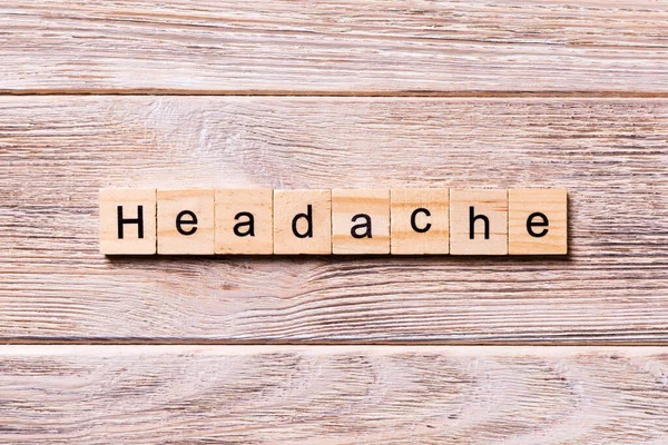 Palabra de dolor de cabeza escrita en bloque de madera. texto dolor de cabeza en la mesa de madera para su diseño, coronavirus concepto vista superior — Foto de Stock