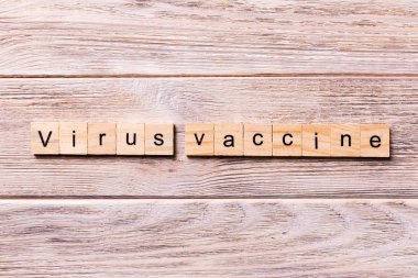Virüs aşısı kelimesi tahta blokta yazılı. Virüs aşısı metni ahşap masa üzerinde Coronavirus konsepti üst görünümün için
