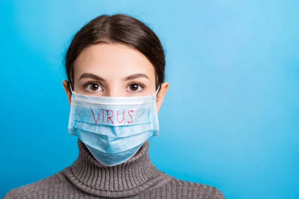 Portretul unei femei frumoase care poartă mască medicală cu text de virus pe fundal albastru. Conceptul de coronavirus. Protecție respiratorie — Fotografie, imagine de stoc