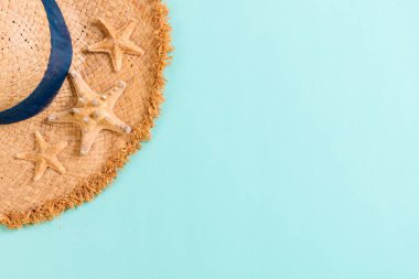 Beach hat with seashells on brown blue table. summer background 