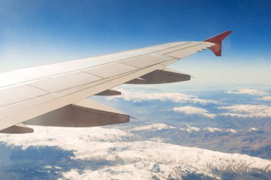 dağların üzerinden uçar uçağın penceresinden görünümü