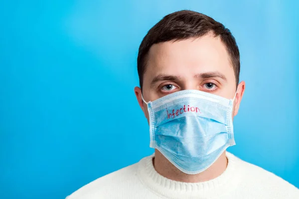 Porträtt av en sjuk man bär medicinsk mask med infektion text på blå bakgrund. Coronavirus-konceptet. Skydda din hälsa — Stockfoto